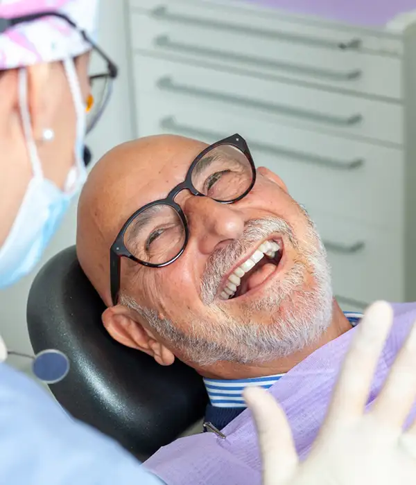 senior adult man smiling and laughing before a dental procedure