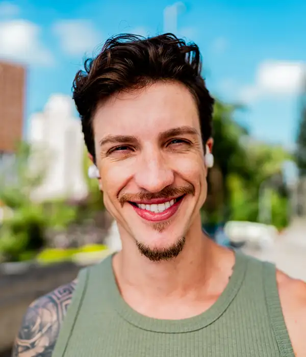 young adult man with tattoos smiling