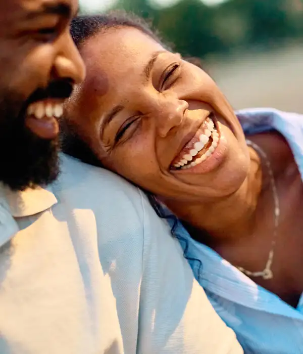 woman smiling and leaning on her partner's shoulder