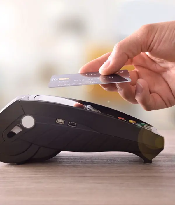 hand holding credit card up to payment machine