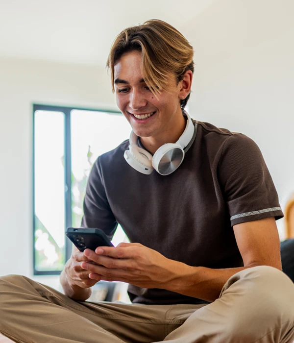 teenage boy using his phone and smiling